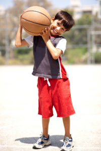 Junge mit Basketball auf seinen Schultern im Freien