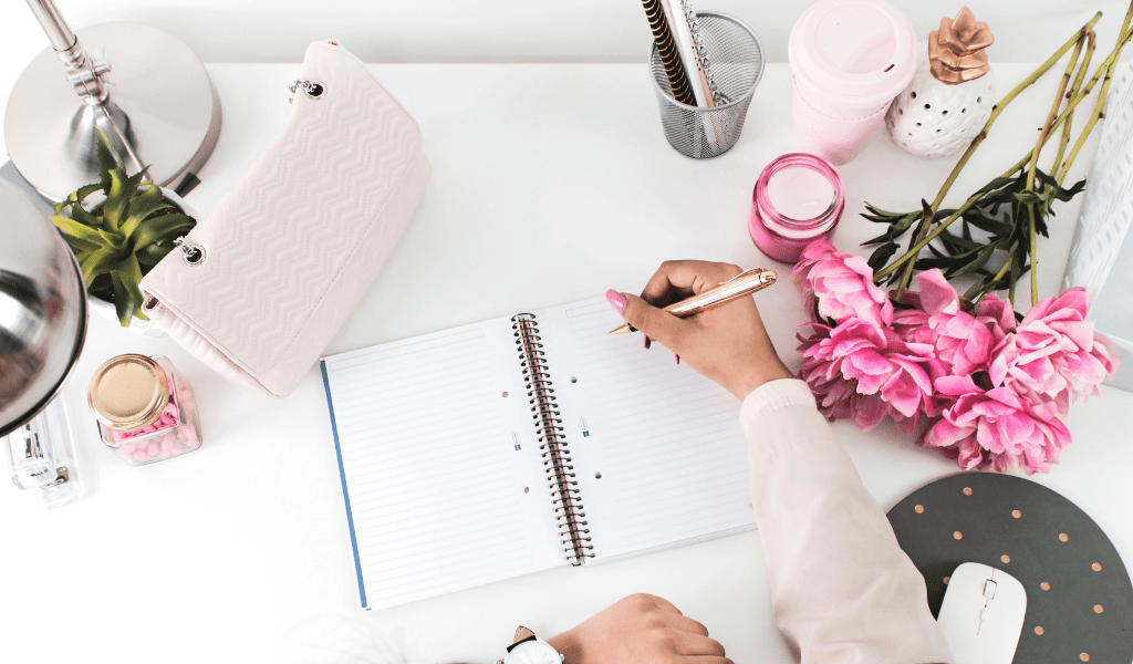 desk with pink flowers and notebook