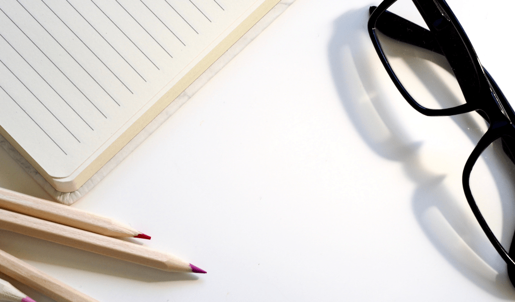 glasses and notepad with pencils