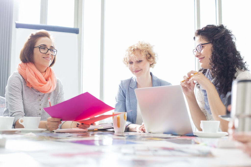 three young adult females at a table 