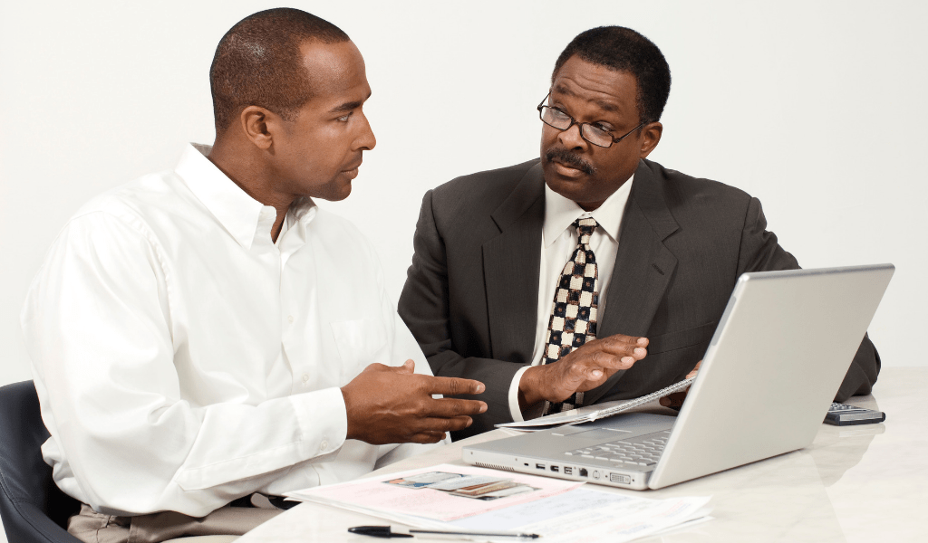 men looking at investments on a computer