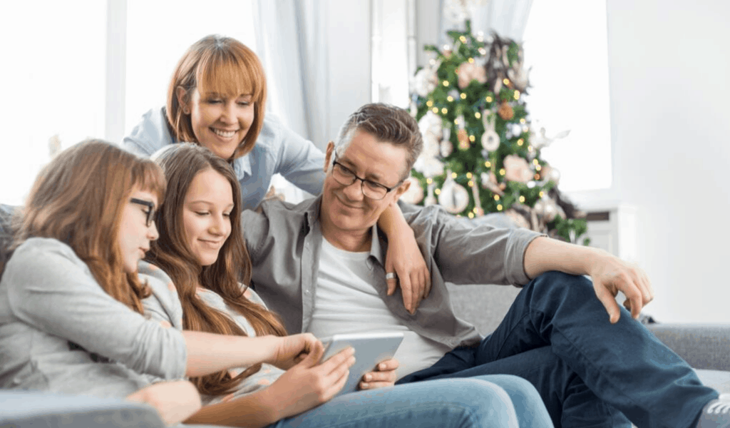 family at Christmas looking at tablet