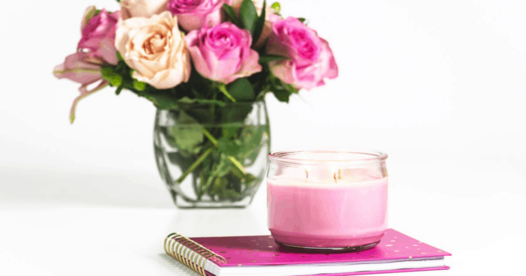 pink flowers in a clear vase, pink notebook and pink candle