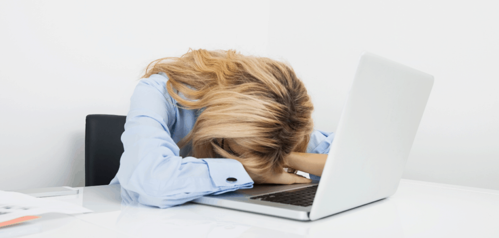 woman laying head on computer
