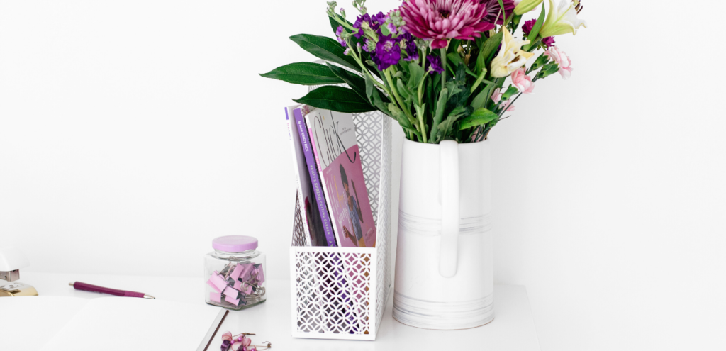 white desk with purple flowers and office supplies