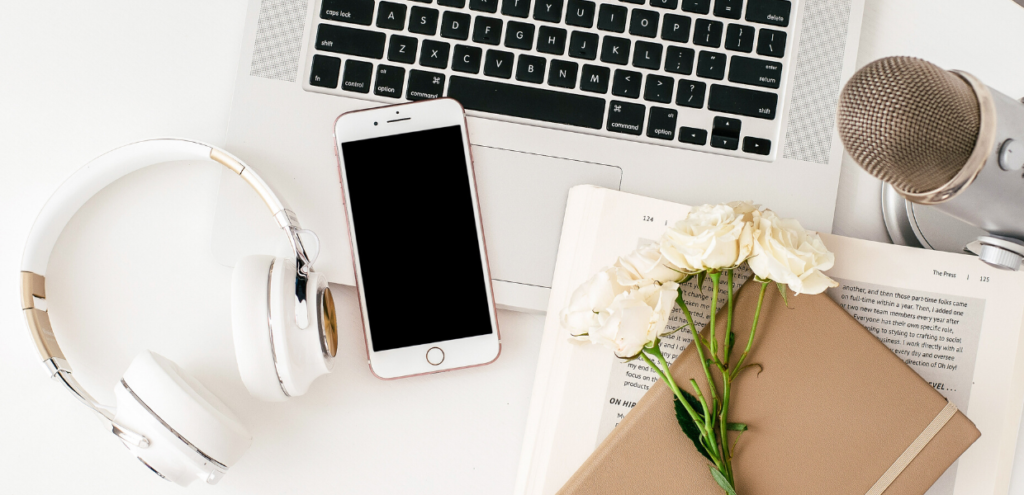 computer and podcast mic with white rose flowers on desk, so she can make money online fast