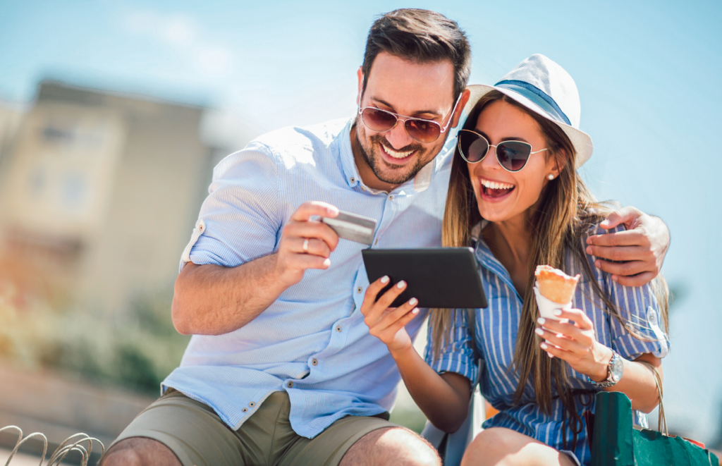 man and woman looking at tablet with  credit card