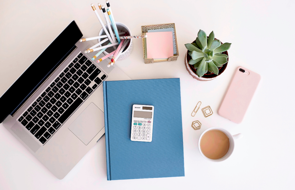 blue journal with laptop and calculator