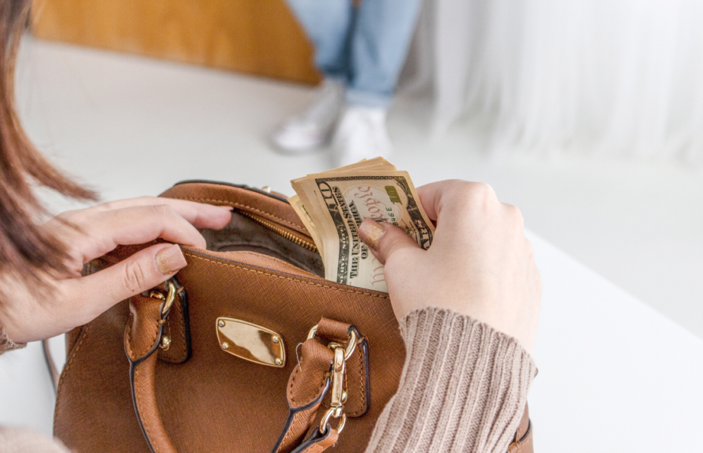 woman putting cash in purse