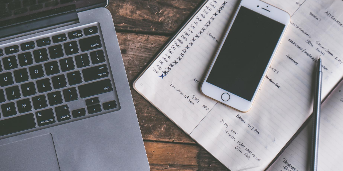 Desk with notebook for budgeting and phone laying on top