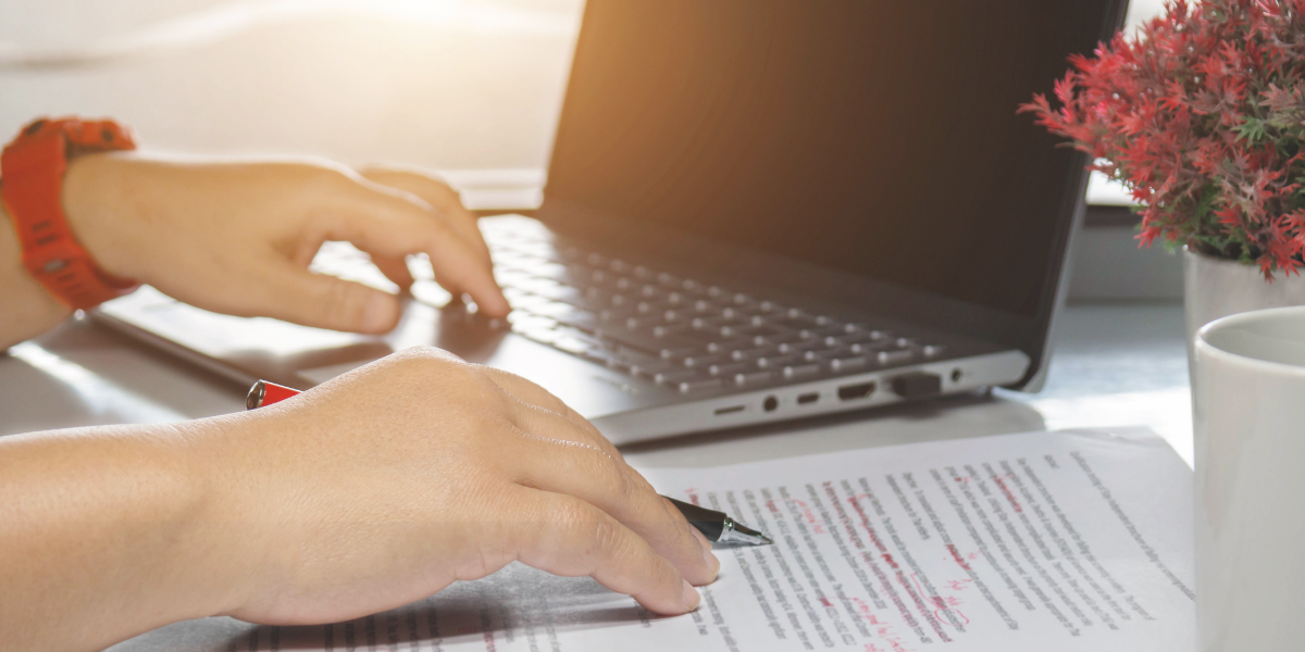 Person working on laptop while proofreading