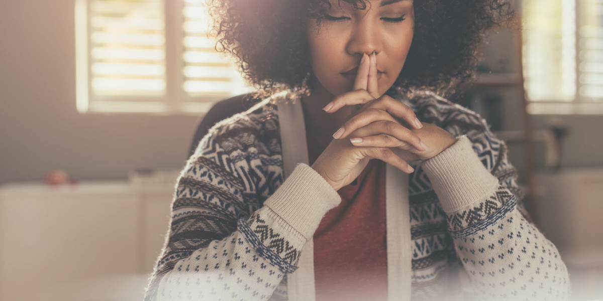 Black female sitting with her eyes closed thinking and or meditating 