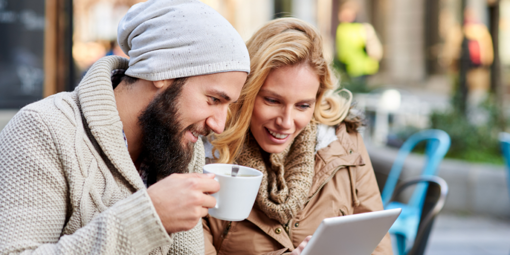 man and woman using free internet outside a coffee shop