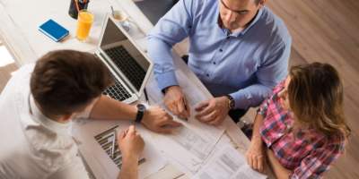 Financial advisor assisting couple with investing their money and earnings to pay off debt. 