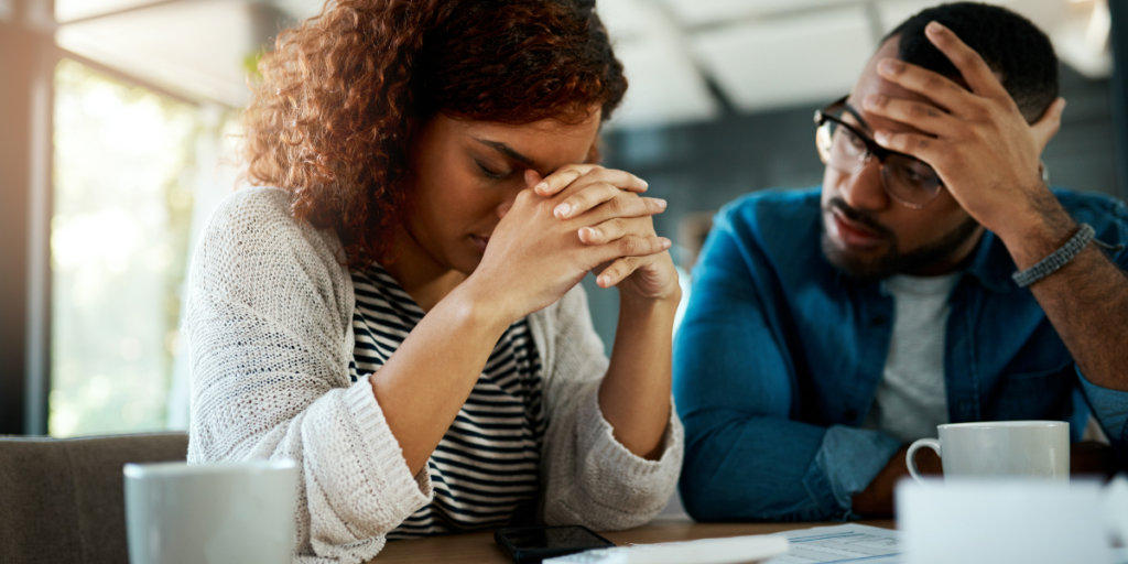 Couple worrying about debt and wondering if they will ever be able to secure their financial future and change their money mindset.