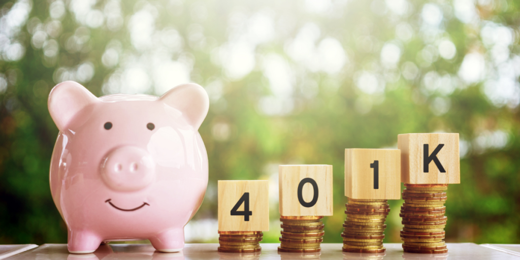 A piggy bank sitting on a table beside stacked change with blocks labeled 401K and sticking to ones budget. 
