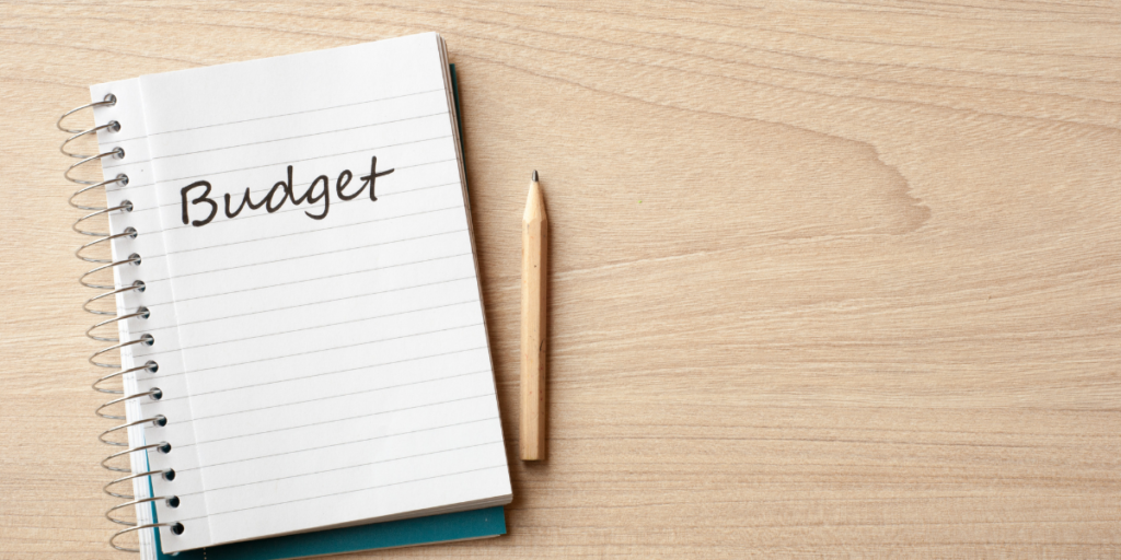 A budget notebook and a pencil on a table top used to stick to a budget. 