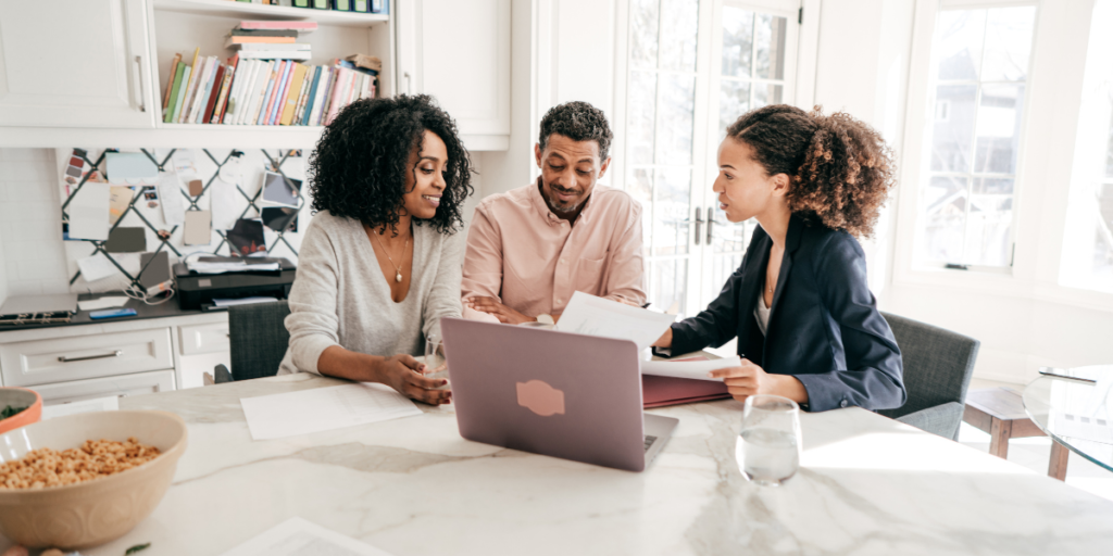 A couple speaking with a financial advisor about how to become a millionaire. 