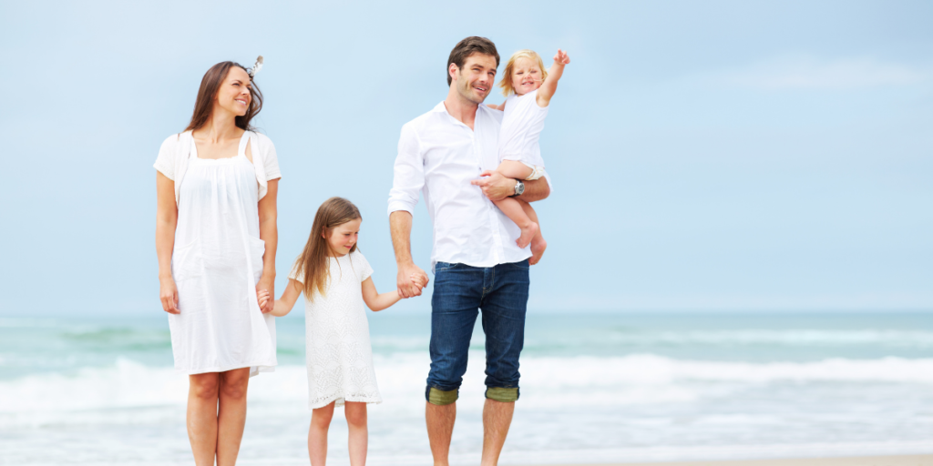A family on the beach enjoying quality time together due to being able reach their financial goals. 