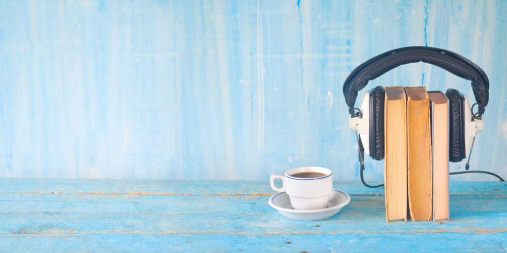 A stack of books with headphones on beside a cup of coffee listening to hoopla where you can also enjoy free movies online. 