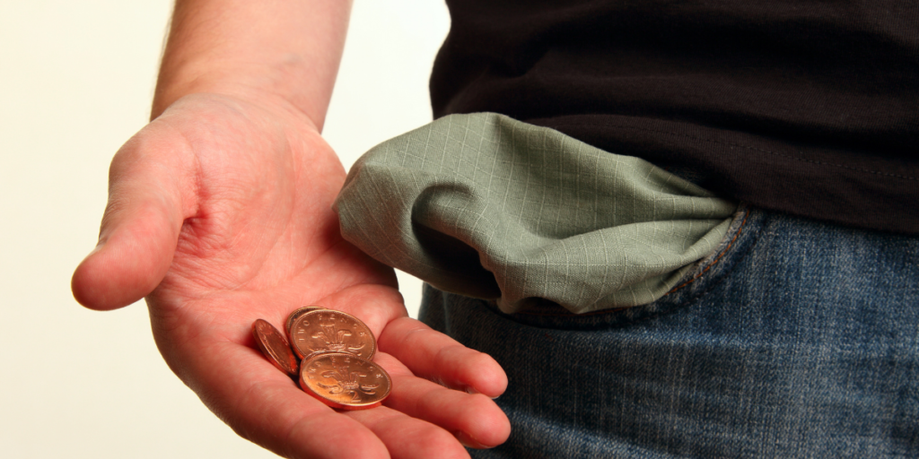 A guy showing the change in his hand that he pulled from his pocket reminding him he needs to stick to a budget. 