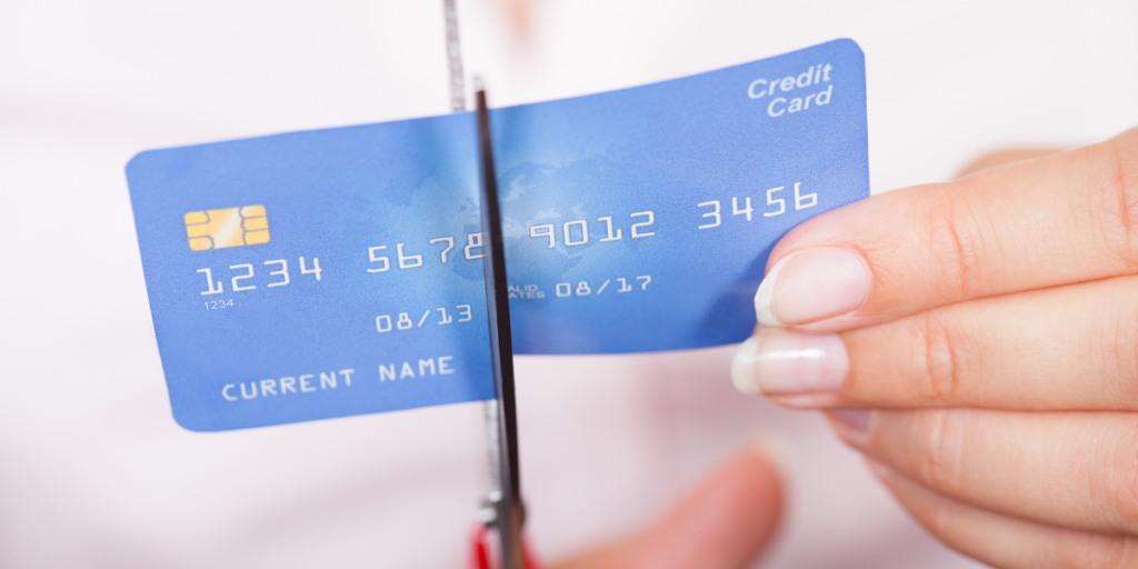 A lady cutting up a credit card to reach her financial goals.