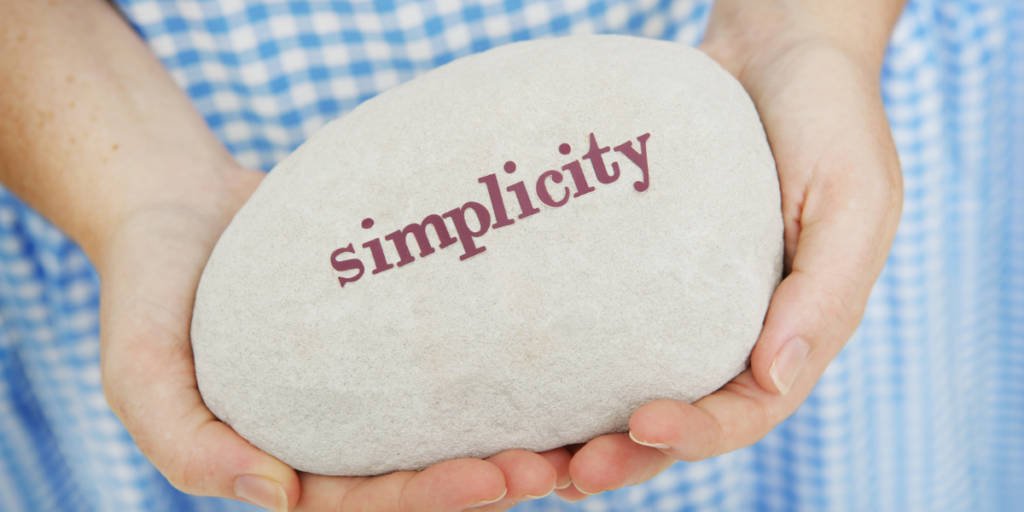 A woman wanting to become a millionaire holding a white rock with the word simplicity.