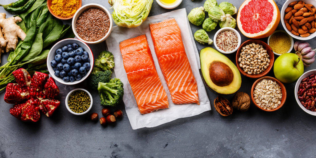 Healthy foods spread out over a table top and a reminder that eating the right and healthy foods can help one have the physical energy to stay motivated. 