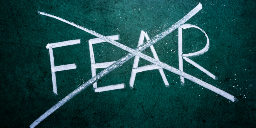 The word FEAR crossed out on a chalkboard.  Don't let fear keep you from staying motivated. 