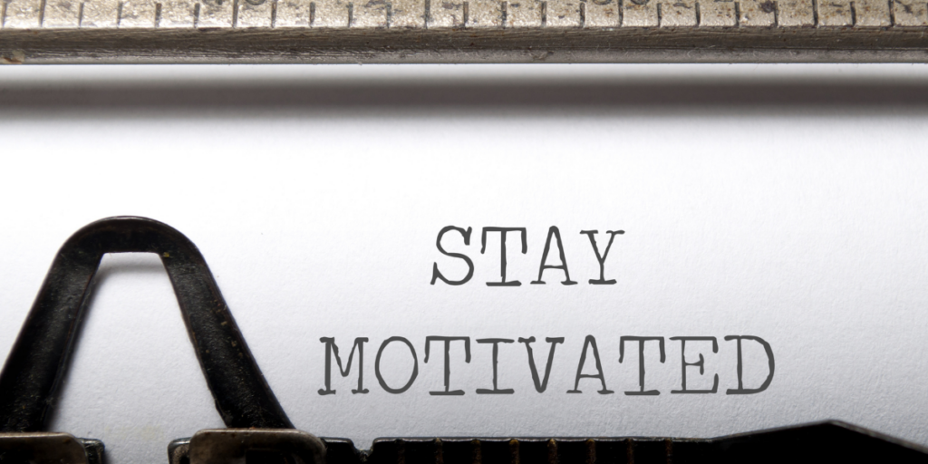 Stay Motivated typed on a piece of paper still in the typewriter reminder the reader to stay motivated on their budgeting journey. 