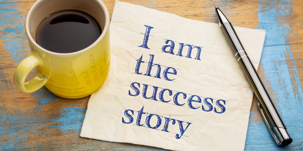 "I am the success story" printed on a napkin laying beside a pen and a yellow cup of coffee reminding us that we are the creators of our success and how we can hustle without money upfront.  