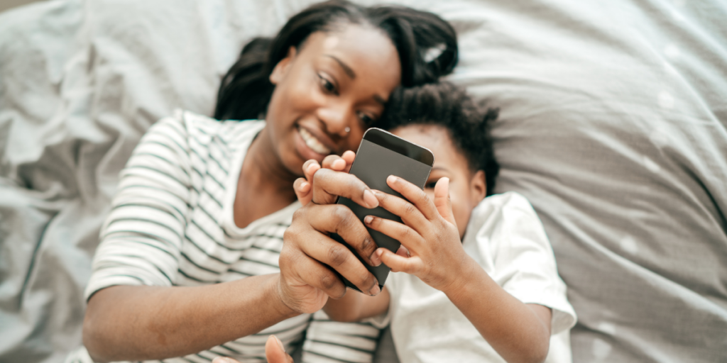 A mom teaching her son how to earn amazon gift cards online using apps on her phone. 