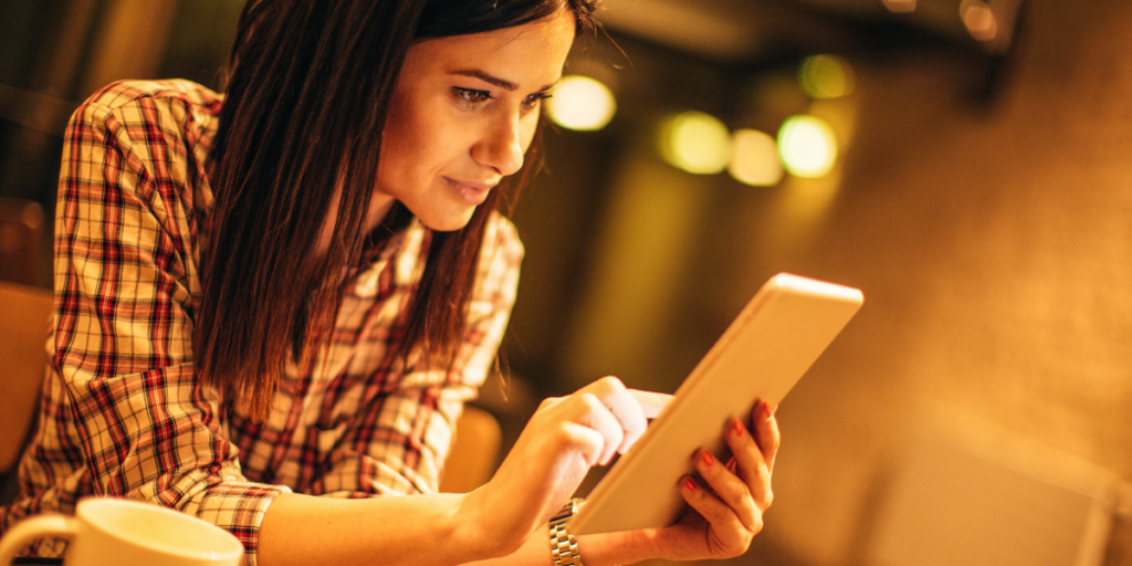 A woman earning rewards and gift cards online watching videos and shopping online using her tablet.  