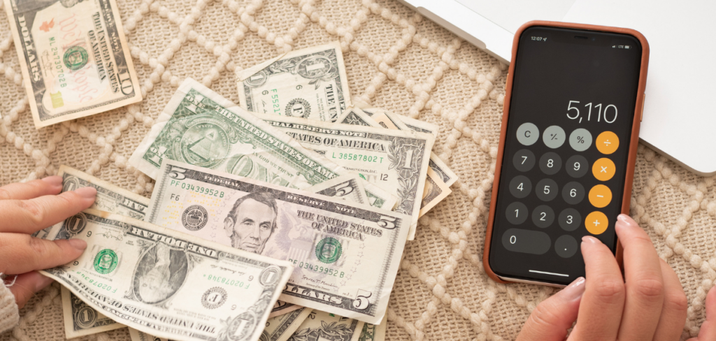 A woman budgeting her money and calculating using her cellphone