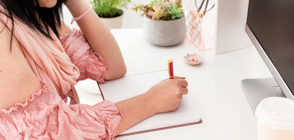 A woman writing on a notebook