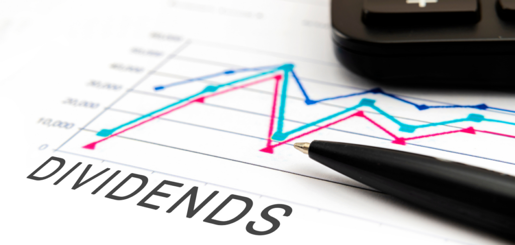 a calculator, a pen, and a paper with a line graph and the word DIVIDENDS