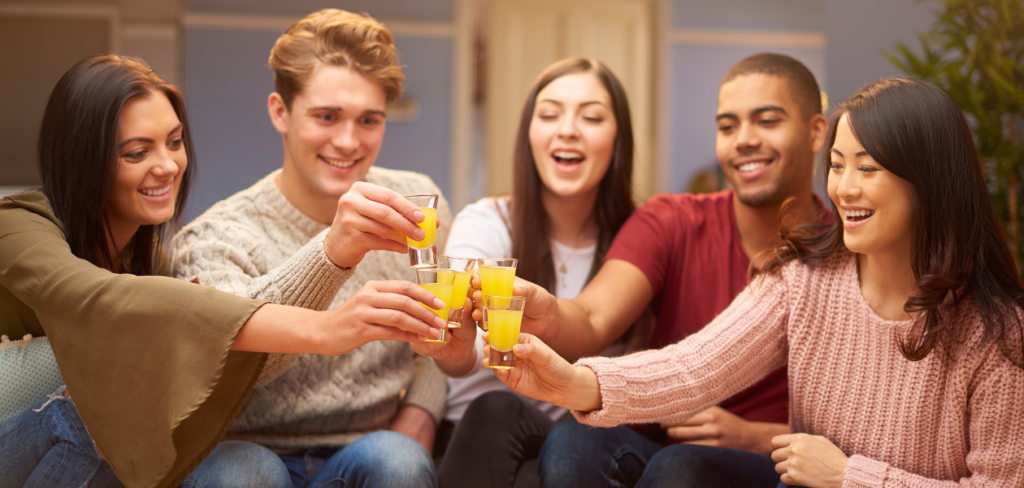 Group of friends making a toast with shot glasses