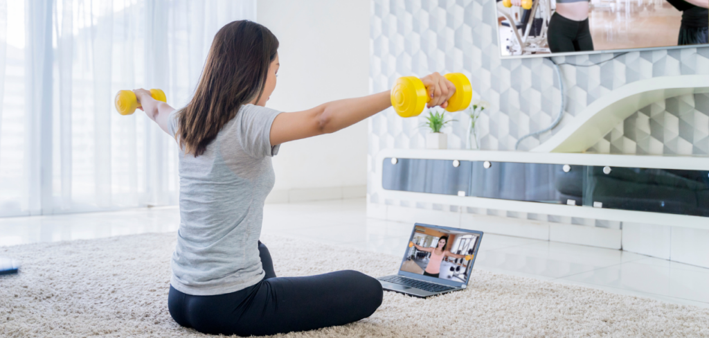Woman working out at home with a trainer online
