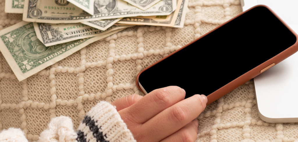 Cell phone with girl's hand and money.