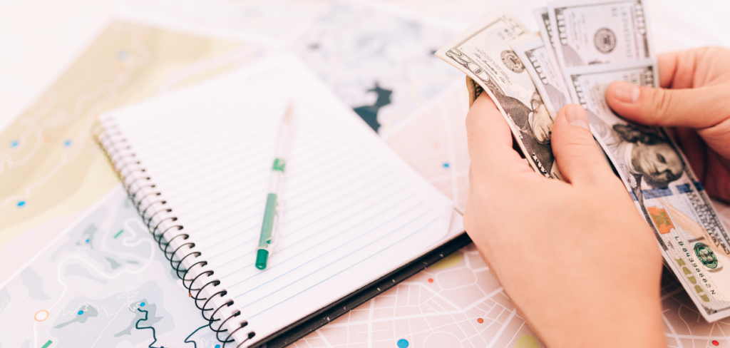 Notebook on desk and a person counting money