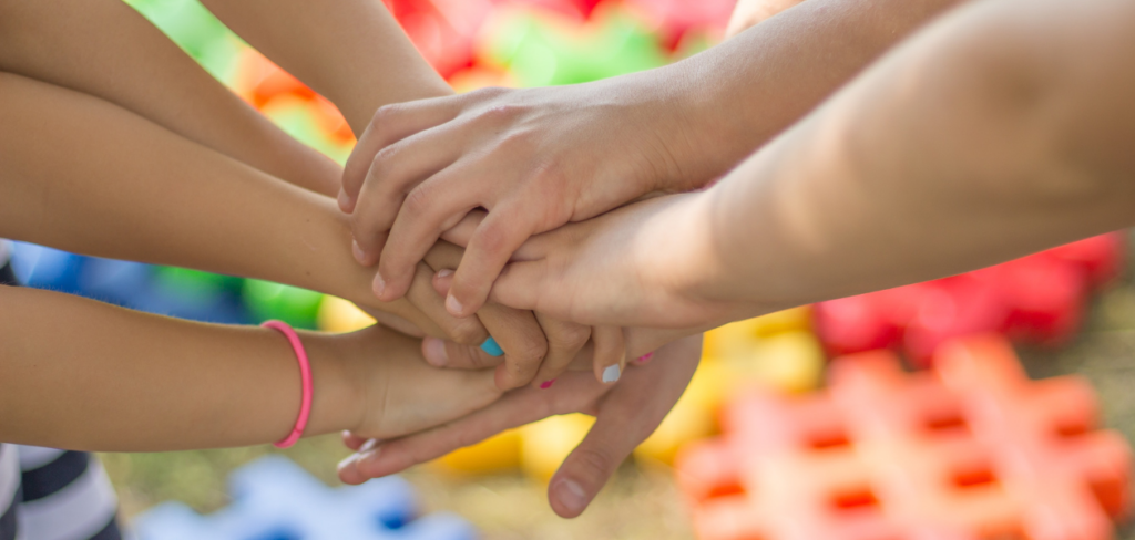 Closeup of hands stacked upon one another.