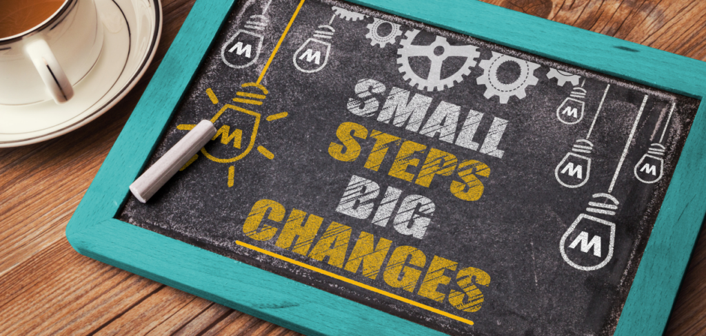 The phrase small steps big changes written on blackboard.