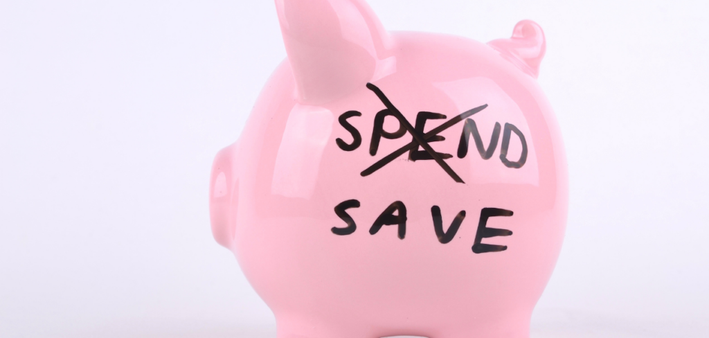 The words spend and save written on a piggybank