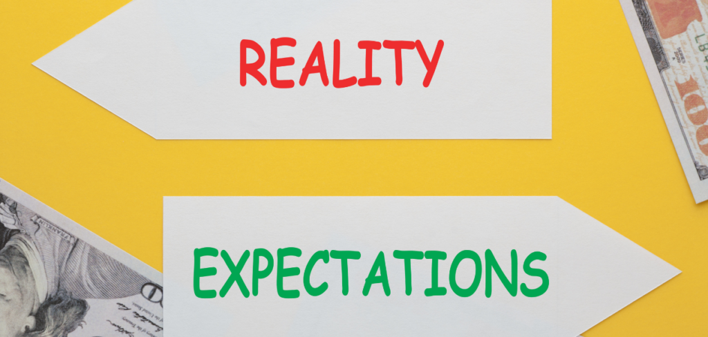 The words Reality vs Expectations written on paper arrow with hundred dollar bills.