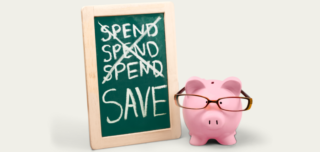Piggy bank and chalkboard with spend and save words.
