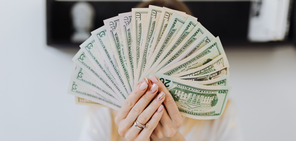 A person holding a fan of US dollars.