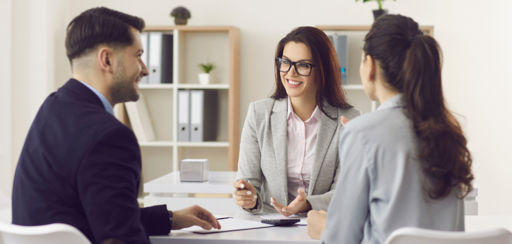 A woman financial advisor is giving advice to a couple about their money.