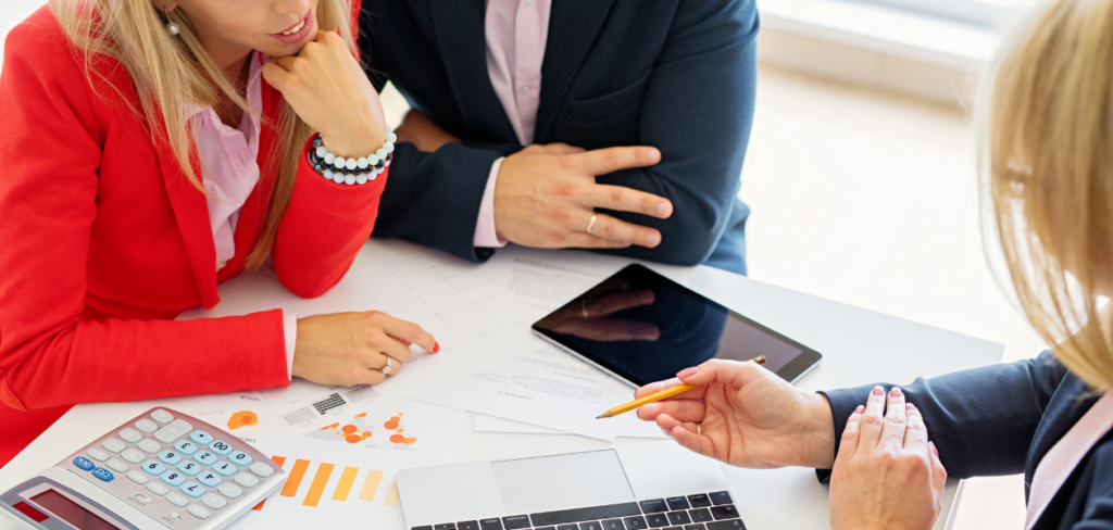 A couple meeting with a financial advisor looking at papers about their assets.
