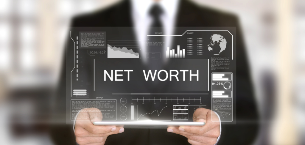A businessman holding a tablet showing graphs about net worth.