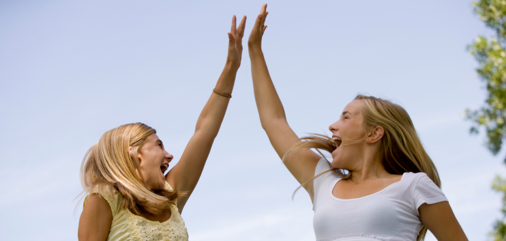 Two girls high-fiving.